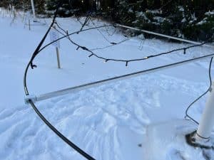 Krans med ljusslingor runt flaggstång